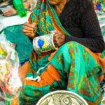 a woman sitting on the ground working on a piece of art