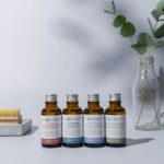 a group of bottles of essential oils next to a plant